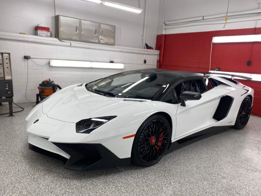 White Lamborghini Aventador on full flake polyaspartic floor — Premier Sports Cars Springfield MO — Ozarks Concrete Coatings